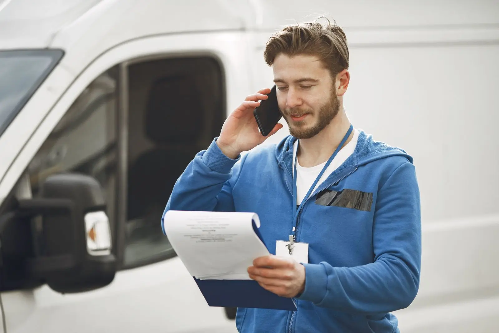Handwerker telefoniert mit Auftraggeber und macht Notizen