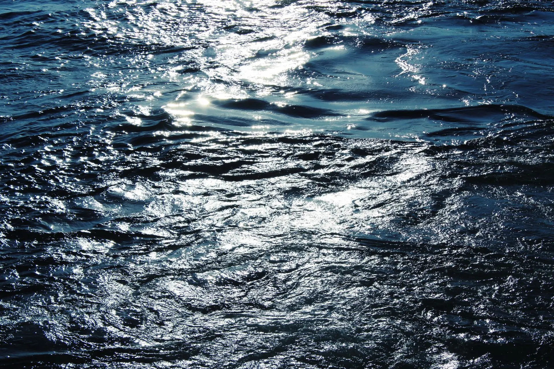 Sonnenlicht glitzert auf einer bewegten Wasseroberfläche
